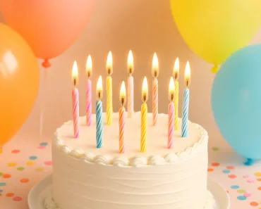 Um bolo de aniversário lindamente decorado com velas acesas, rodeado por balões coloridos e confetes, sobre um fundo pastel suave. A cena evoca alegria, celebração e calor. Imagem vertical.